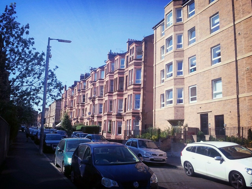 A row of sandstone tenement flats on a street in Glasgow