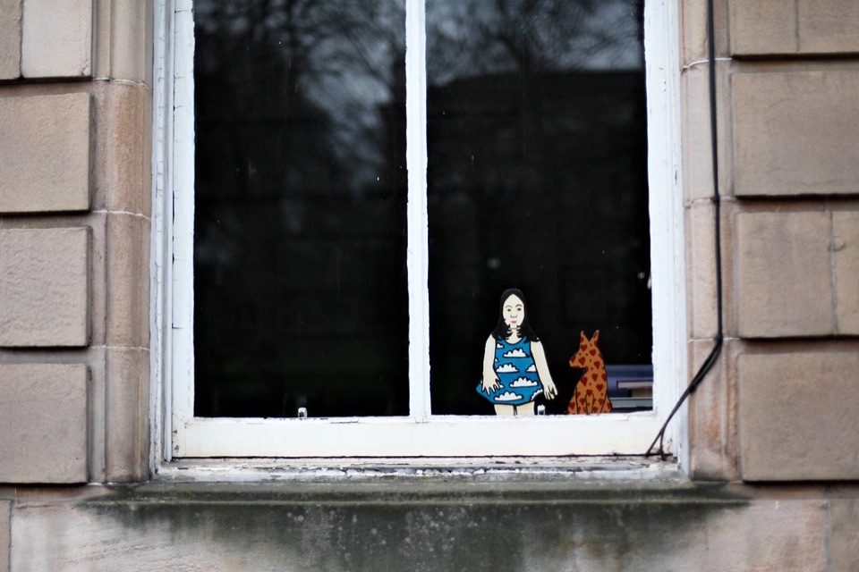 A sash window set in a dressed sandstone surround on a Glasgow tenement